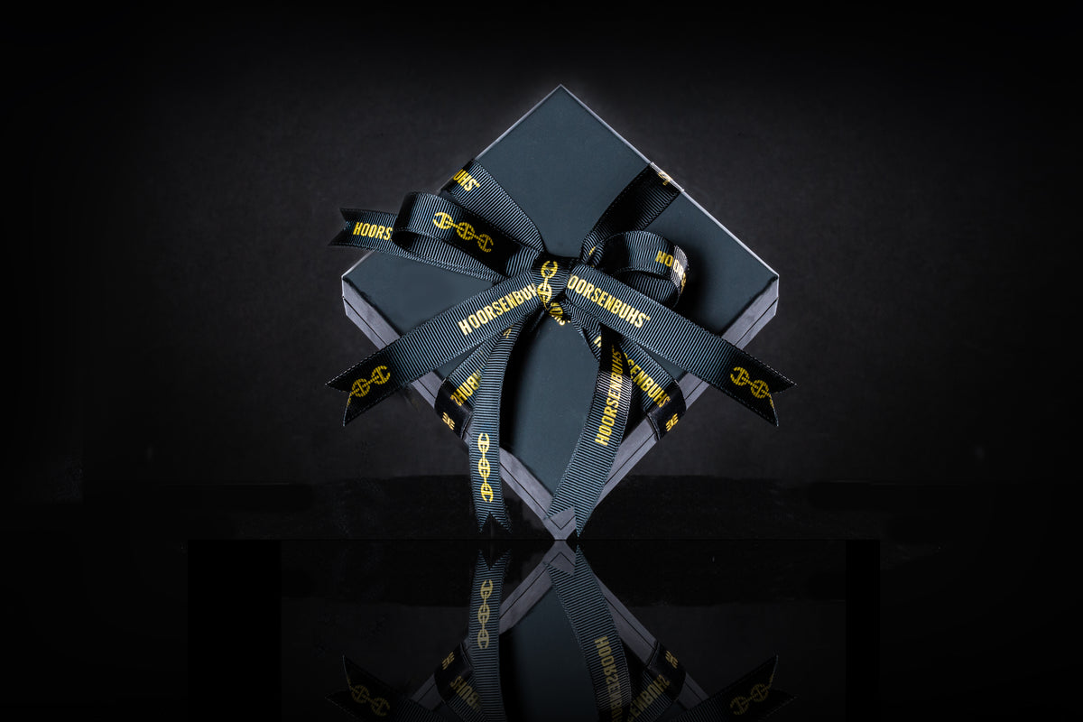 A HOORSENBUHS gift wrapped in black with the signature ribbon